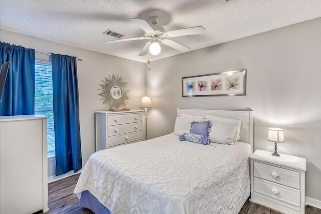 bedroom featuring a textured ceiling, ceiling fan, and dark wood-type flooring