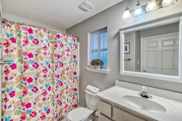 bathroom with toilet, a shower with shower curtain, vanity, and a textured ceiling