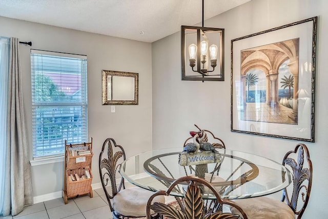 dining area featuring a textured ceiling, an inviting chandelier, and light tile patterned floors