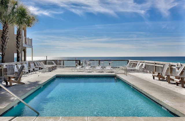 view of swimming pool with a patio area and a water view