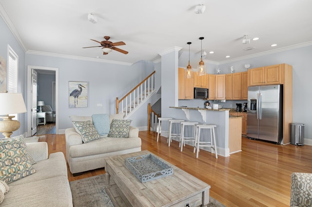 living room with crown molding, light hardwood / wood-style floors, and ceiling fan