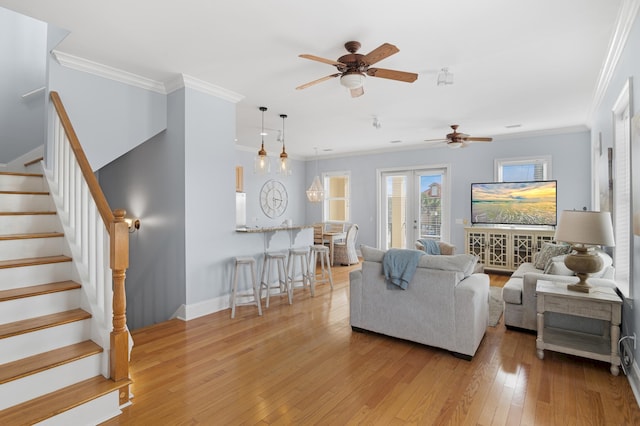 living room featuring crown molding, ceiling fan, and light wood-type flooring