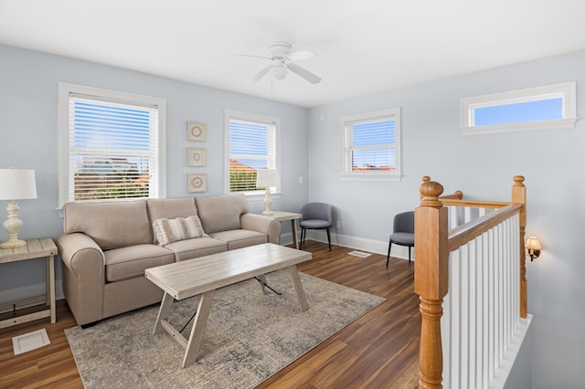 living room with dark wood-type flooring and ceiling fan