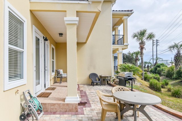 view of patio with a grill and a balcony