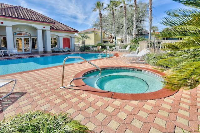 view of swimming pool with french doors, a patio, and a community hot tub