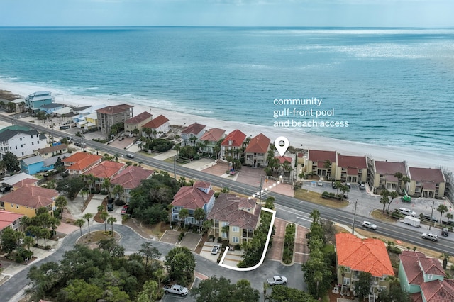 birds eye view of property with a water view and a view of the beach