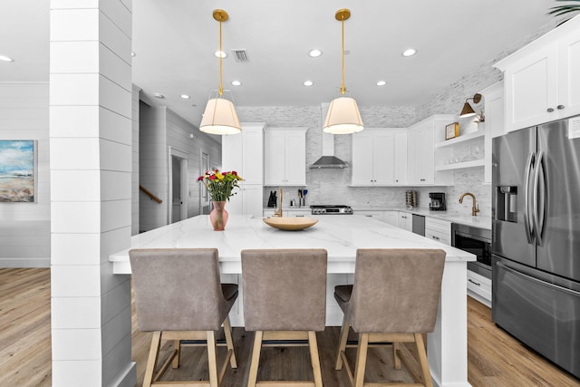 kitchen with white cabinets, stainless steel appliances, a kitchen island, and pendant lighting