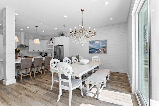 dining area featuring light hardwood / wood-style floors, sink, a wealth of natural light, and a chandelier