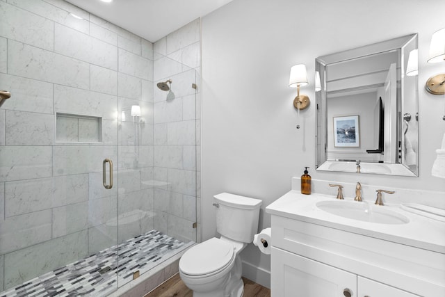 bathroom featuring wood-type flooring, walk in shower, vanity, and toilet