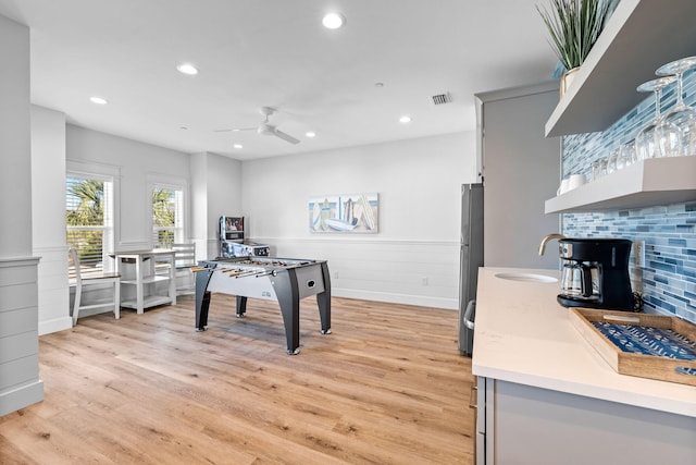 playroom featuring light wood-type flooring, ceiling fan, and sink