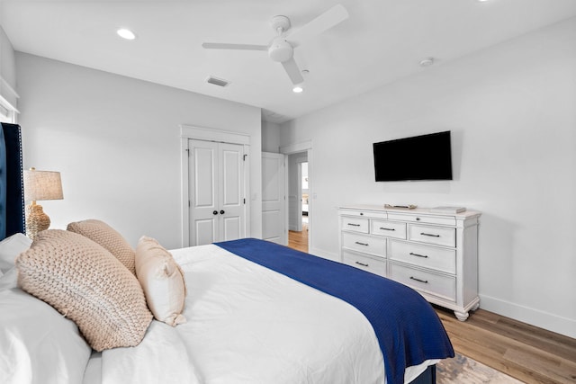 bedroom featuring ceiling fan, a closet, and light hardwood / wood-style flooring