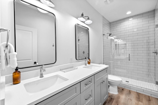 bathroom with hardwood / wood-style floors, an enclosed shower, vanity, and toilet