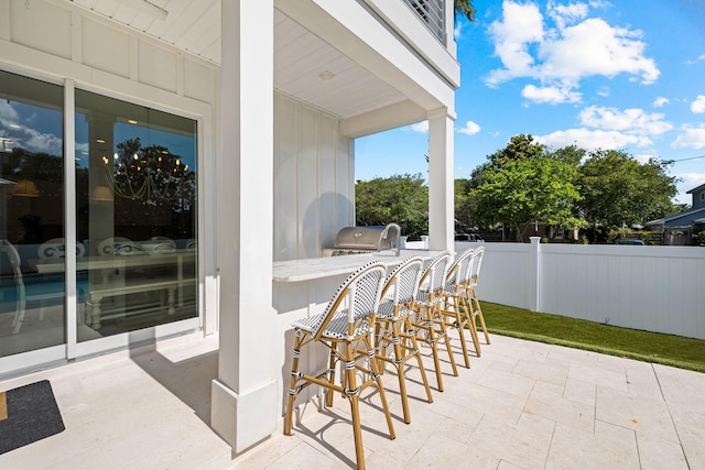 view of patio / terrace featuring exterior kitchen, a bar, and a grill