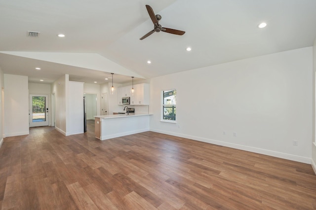 unfurnished living room with ceiling fan, vaulted ceiling, and light hardwood / wood-style flooring