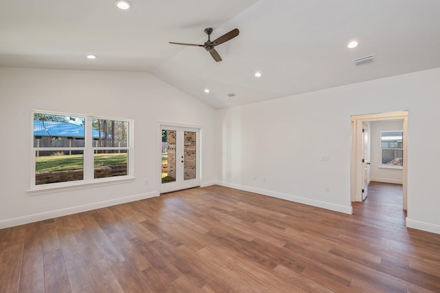 empty room with ceiling fan, lofted ceiling, and wood-type flooring