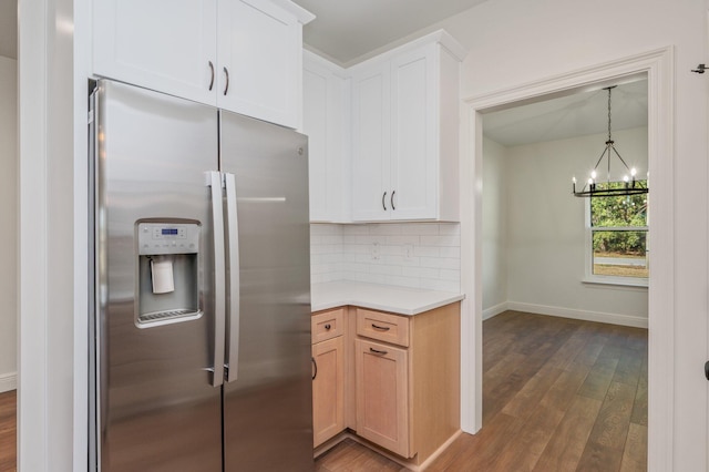 kitchen with white cabinets, stainless steel refrigerator with ice dispenser, dark hardwood / wood-style flooring, decorative backsplash, and a notable chandelier