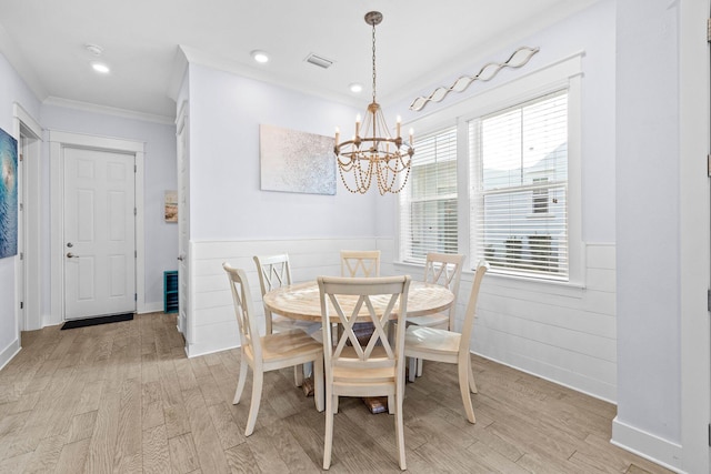 dining room featuring a chandelier, light hardwood / wood-style floors, and crown molding