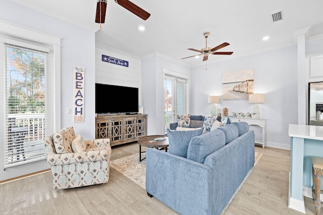 living room with light wood-type flooring and crown molding