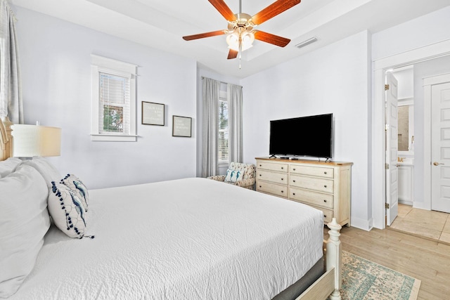 bedroom with ensuite bathroom, ceiling fan, and light hardwood / wood-style floors