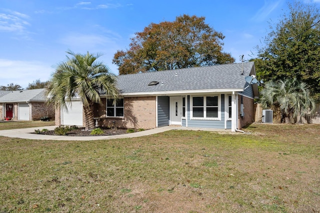 ranch-style home with central AC unit, a front yard, and a garage