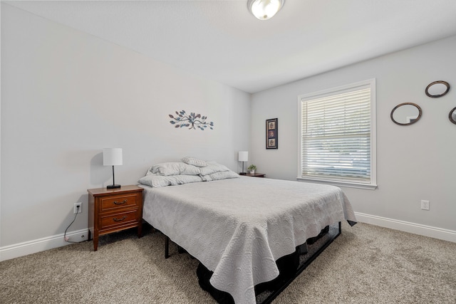 bedroom featuring light colored carpet and baseboards