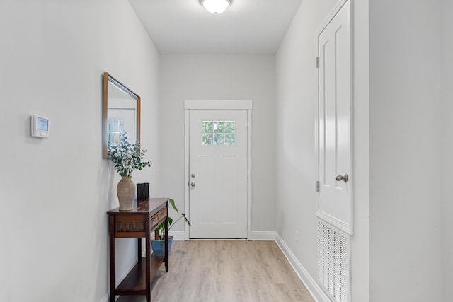 doorway to outside featuring visible vents, light wood-style flooring, and baseboards