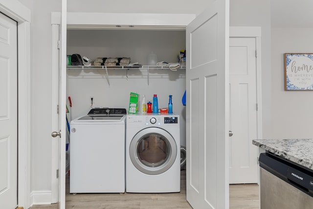 laundry area featuring laundry area, light wood finished floors, and washing machine and clothes dryer