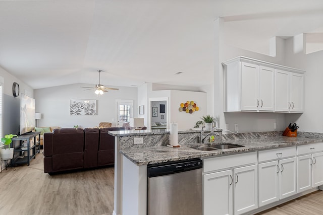 kitchen featuring light stone counters, a sink, white cabinetry, open floor plan, and stainless steel dishwasher