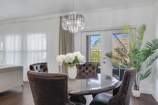 dining space featuring dark hardwood / wood-style flooring, ornamental molding, and a chandelier