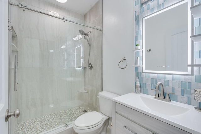 bathroom with toilet, vanity, backsplash, and an enclosed shower