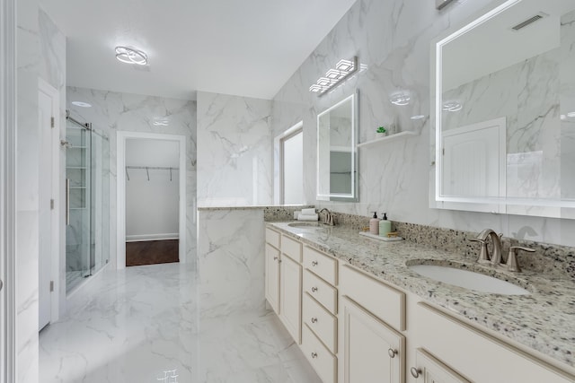 bathroom with an enclosed shower, vanity, and tile walls