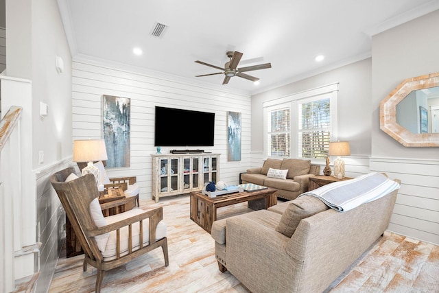 living room featuring ceiling fan, crown molding, and light hardwood / wood-style flooring