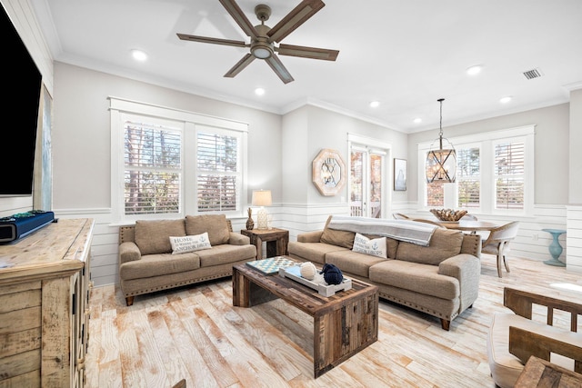 living room with ornamental molding, ceiling fan, and light hardwood / wood-style flooring