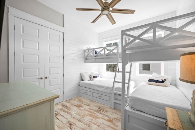 bedroom with ceiling fan, light wood-type flooring, and a closet