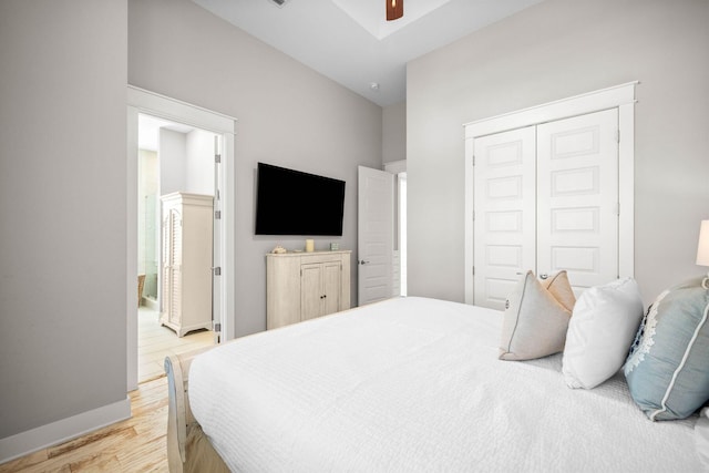 bedroom with light wood-type flooring, ceiling fan, and a closet