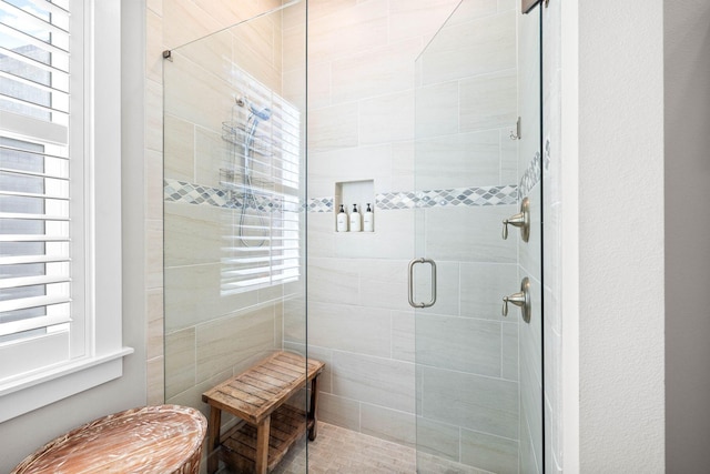 bathroom featuring a shower with shower door