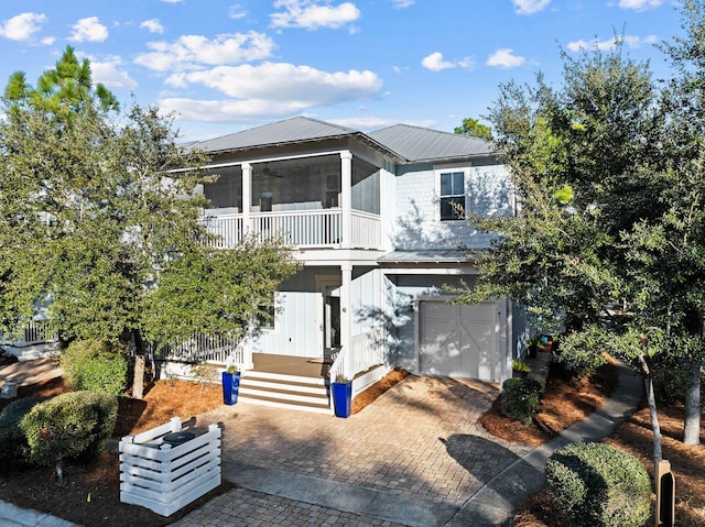 view of front of property with a garage and a sunroom