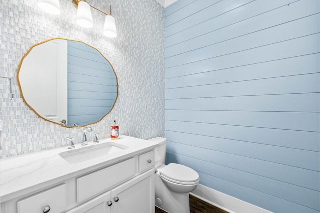 bathroom featuring vanity, backsplash, and toilet