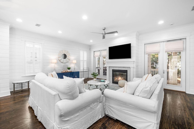 living room featuring ceiling fan and dark hardwood / wood-style floors