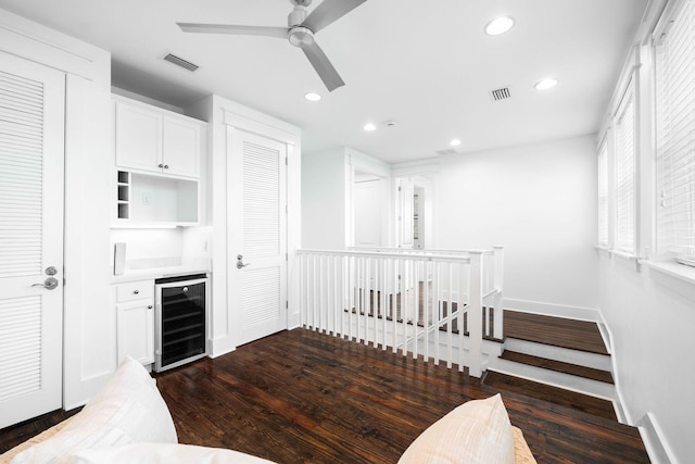 kitchen featuring dark hardwood / wood-style floors, ceiling fan, beverage cooler, and white cabinets