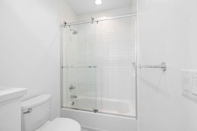 full bathroom with bath / shower combo with glass door, vanity, and toilet