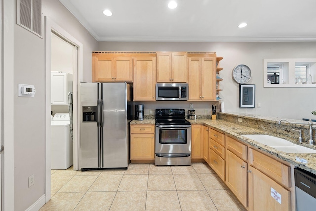 kitchen with washer / clothes dryer, stainless steel appliances, crown molding, light stone counters, and sink