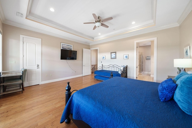 bedroom featuring connected bathroom, a raised ceiling, ceiling fan, and light hardwood / wood-style floors