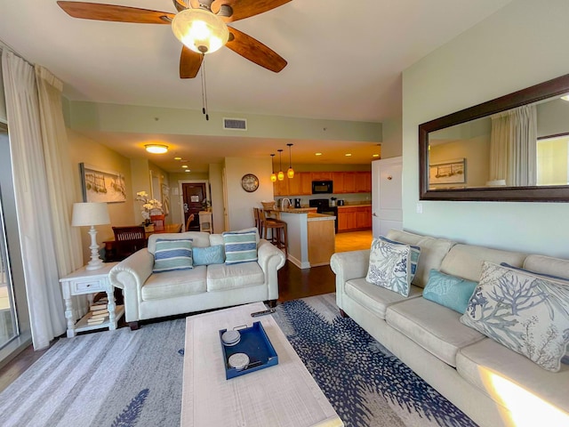 living room with ceiling fan and light hardwood / wood-style floors