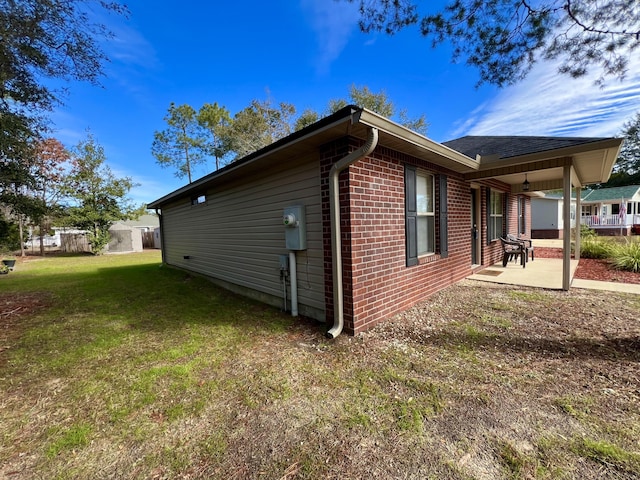 view of property exterior with a patio area and a yard