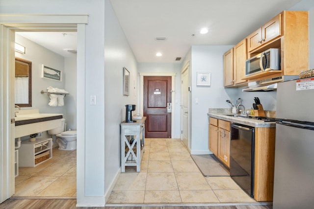 kitchen with stainless steel appliances, light tile patterned floors, and light brown cabinets