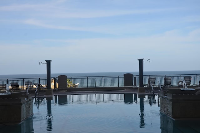 view of swimming pool featuring a water view