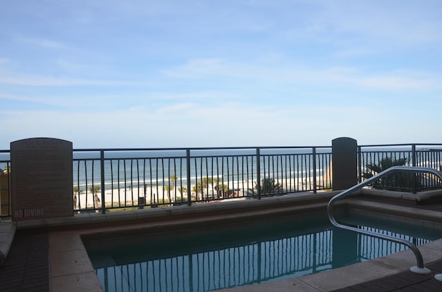 view of pool featuring a beach view and a water view