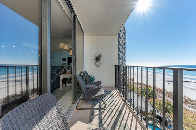 balcony featuring a water view and a beach view