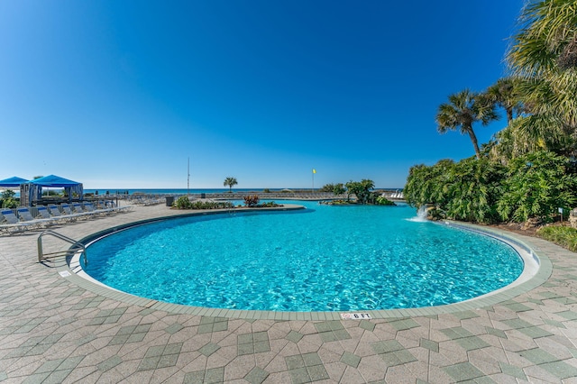 view of swimming pool with a water view and a gazebo